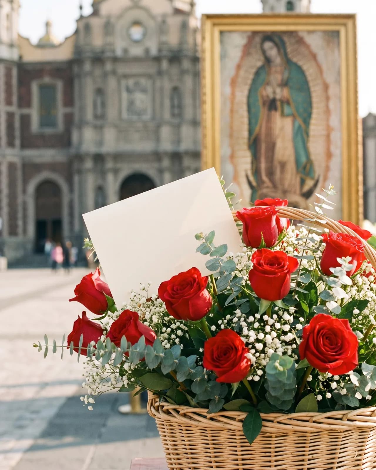 Tarjeta de dedicatoria en un arreglo de rosas rojas para la Virgen de Guadalupe